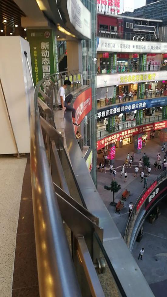 男子坐在栏杆外,十分危险。 本文图片均为警方供图