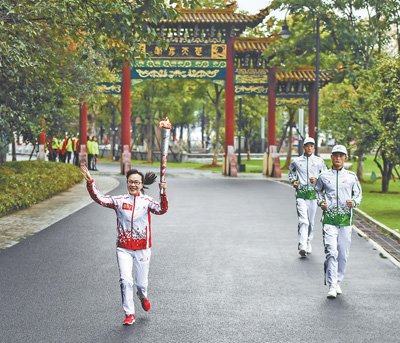 第九十七棒火炬手胡爱娣在武汉东湖绿道传递火炬。尹棣 摄（新华社发）