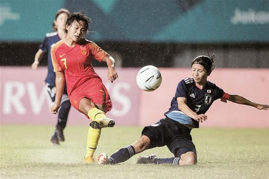 图为：昨晚，雅加达亚运会女足决赛在大雨中进行，中国队第90分钟遭遇绝杀，以0：1不敌日本女足屈居亚军，这已是中国女足近4届亚运会的最佳成绩。图为武汉伢王霜（左）在比赛中射门。 新华社发