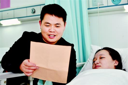 图为:在家属可陪伴的ICU“绿区”内,丈夫谢光平给妻子胡稳朗读“情书”,助她舒缓情绪 楚天都市报记者王永胜摄