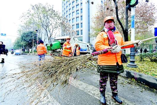 图为同事拿着罗先平生前用过的扫把