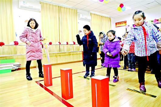 图为:南望山小学的学生们在体验投壶游戏