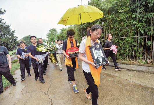 图为：妻子亢群与儿子黄海智，分别捧着黄群的遗像与骨灰盒走进玉笋山陵园，勇士英魂回到了他魂牵梦绕的故乡 楚天都市报记者萧颢摄