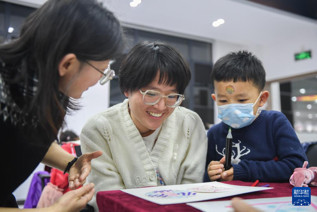 1月11日，在武汉市洪山区五环商圈服务业集聚区党群服务中心二楼，课程教师王菲（左一）指导学员学习曼陀罗绘画。新华社记者 杜子璇 摄