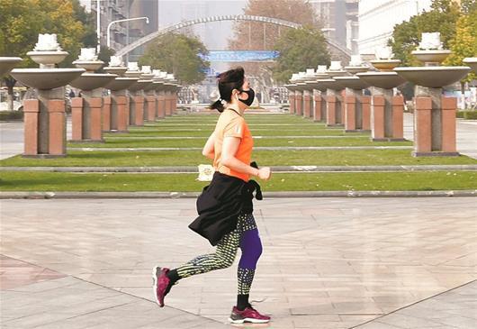 图为：汉口江滩一女士穿短袖跑步 楚天都市报记者李辉摄