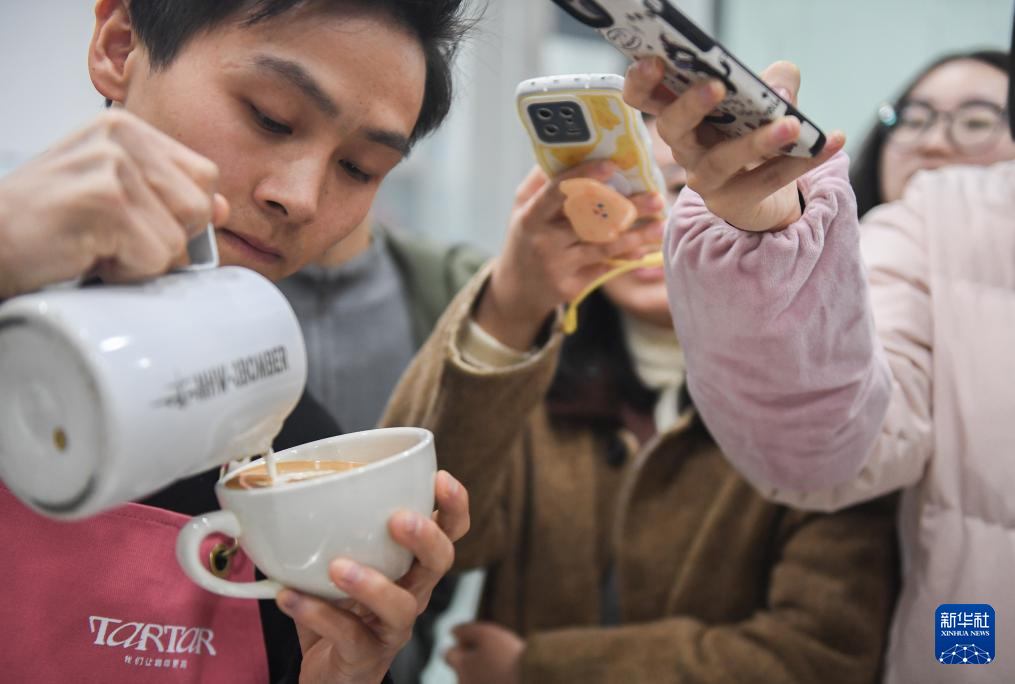 1月4日，在武汉市硚口区古田坊一家咖啡店，教师戴辉（左一）给学员演示咖啡拉花。新华社记者 杜子璇 摄
