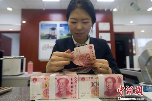 圖為：山西太原，銀行工作人員清點(diǎn)貨幣。中新社記者 張?jiān)?攝