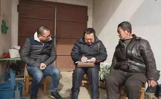 图为:陈新国(中)在高城镇开展“大数据”核查工作