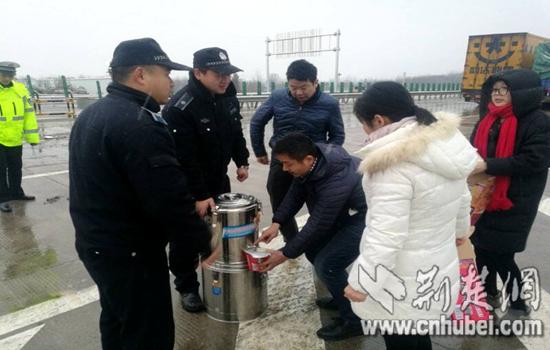 志愿者给被困司乘人员送泡面和热水 刘晓 摄
