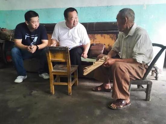 图为:陈新国在农户家中核查精准扶贫问题线索