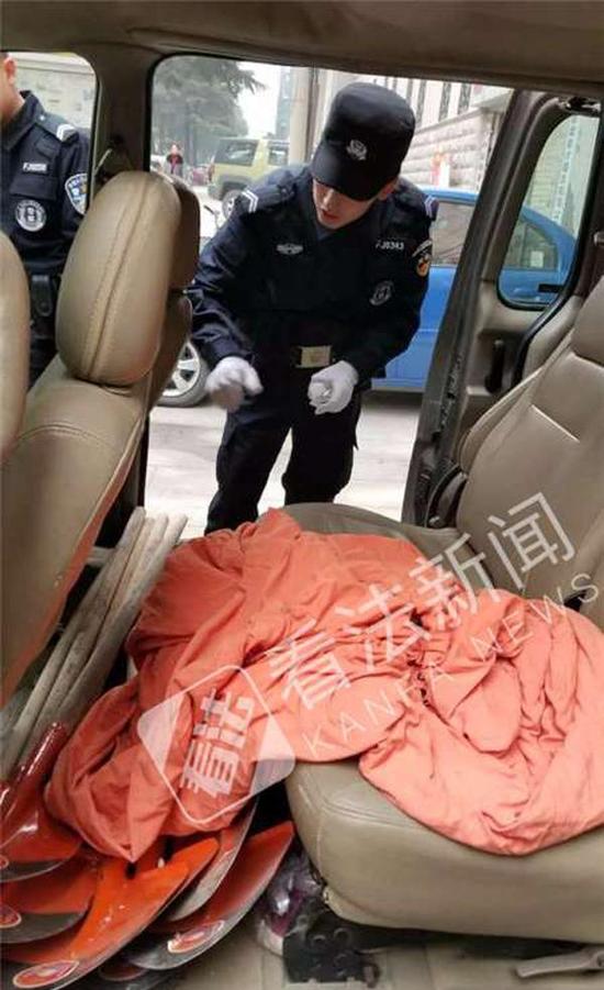 民警检查犯罪嫌疑人车内情况,里面有大量铁锹和布袋等工具。
