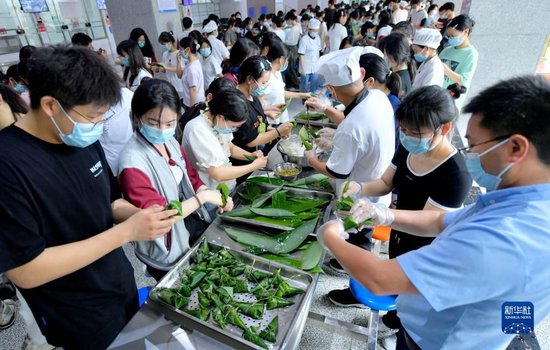 6月4日,湖北省宣恩县一中的高三学生在包粽子。
