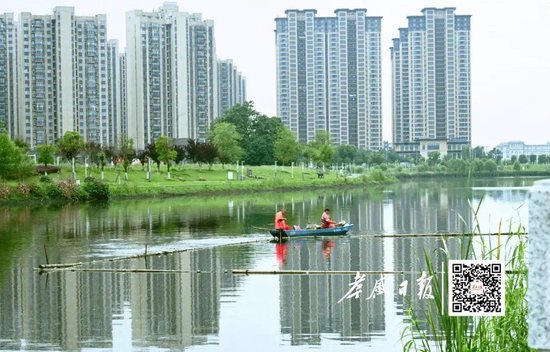 5月27日，几名工人在孝感城区老澴河面打捞水上漂浮物。全媒体记者李文勇摄