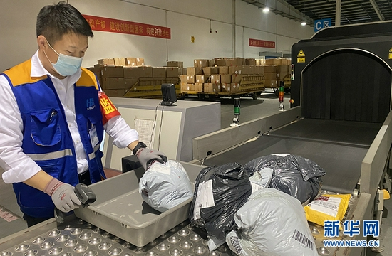 图为“双十一”期间武汉天河机场员工加紧处理货运快件。新华网发