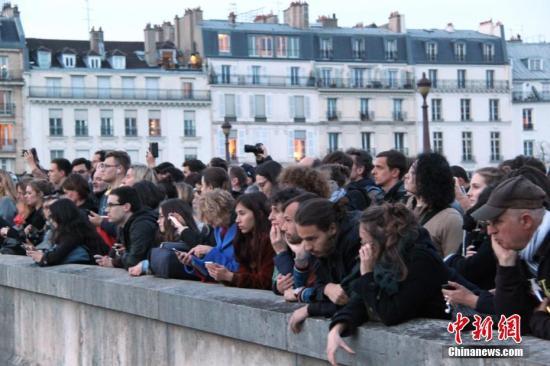 当地时间4月15日晚，法国首都巴黎的著名地标巴黎圣母院发生大火，受损严重。巴黎圣母院大火引发民众高度关注，众多民众在现场附近聚集。中新社记者 李洋 摄