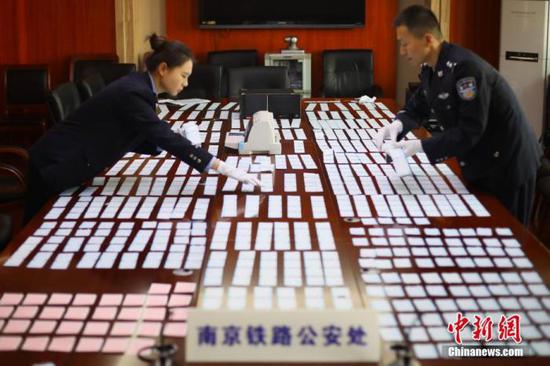 资料图:12月10日,南京铁路公安处民警清点缴获的假火车票。中新社记者 泱波 摄