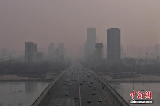 资料图：城市高楼在雾霾中若隐若现。中新社记者 武俊杰 摄