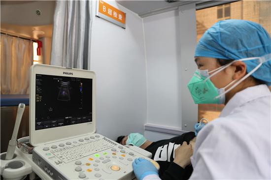 武汉科技大学医院医务人员在移动体检车上进行B超检查(摄影:张宾)