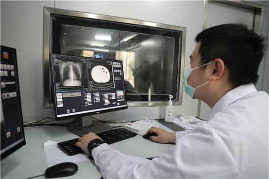 武汉科技大学医院医务人员在移动CT车上进行操作(摄影:张宾)