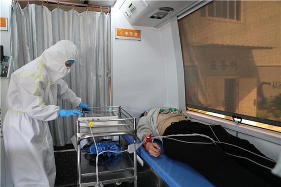 武汉科技大学医院医务人员在移动体检车上进行心电图检查(摄影:张宾)