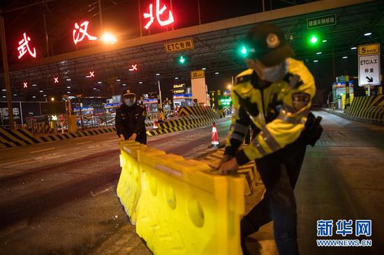 4月8日凌晨，在武汉北高速收费站，工作人员移除围栏。新华社记者 肖艺九 摄