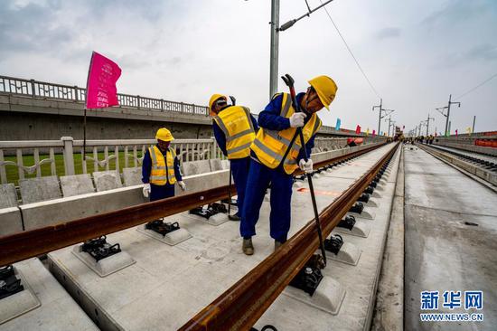 4月8日,中铁十一局三公司建设者在湖北省黄梅县孔垄北站安九高铁铺轨现场校正500米长轨滑动辊轮。