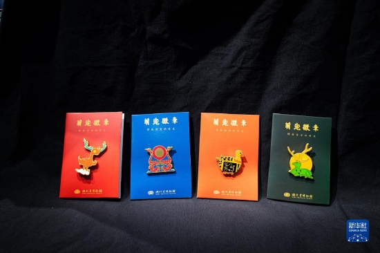 新华社记者 肖艺九 摄
取材于铜鹿角立鹤、彩绘漆木虎座鸟架鼓、彩漆木雕鸳鸯形盒、彩绘漆木卧鹿(从左往右)文物制作的文创徽章(5月12日摄)。