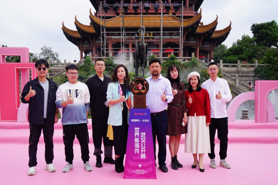 参加奖杯设计制作师生在黄鹤楼前与奖杯合影。