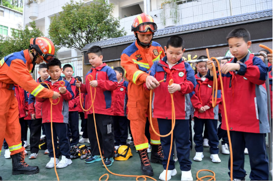 在襄阳市保康县城关镇小学，消防员手把手指导学生打消防绳结。杨韬/摄