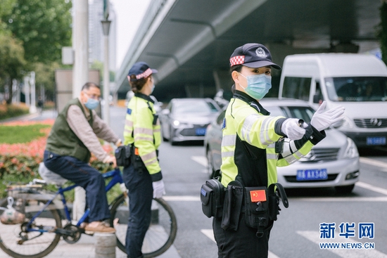 图为湖北省武汉市公安局江岸区交通大队女子快骑队员在路面疏导交通。新华网发 肖俊摄