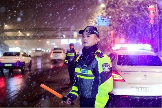 ▲武汉交警在雪中指挥车辆通行