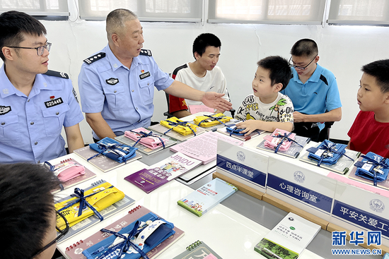 图为武汉市公安局江岸分局百步亭派出所百步亭警务室民警开展暑期儿童安全实践教育。新华网发