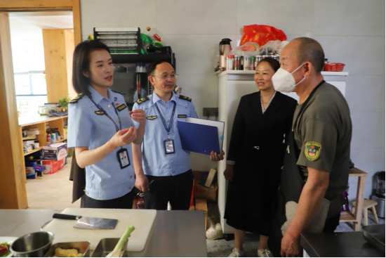 大峡谷所所长李阳(左)和工作人员周大虎(中)检查民宿后厨卫生情况