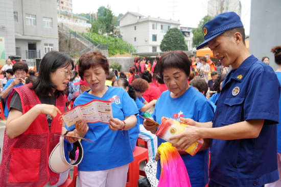 恩施州建始县消防宣传员在广润社区“粽香润聚民心”端午民族文化展演活动现场为群众讲解消防安全常识 胡媛/摄