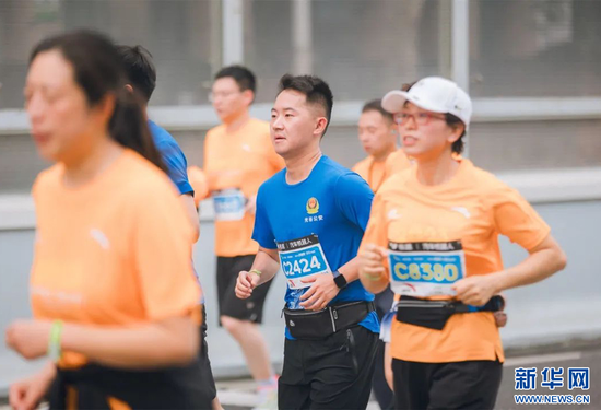 图为武汉公安“护跑团”成员(蓝衣者)在比赛中。新华网发