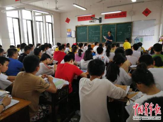6月14日，新化縣上渡街道辦事處明德學(xué)校初中部的學(xué)生在上課，這個(gè)班的學(xué)生94人，老師需戴麥克風(fēng)上課。洪克非 攝