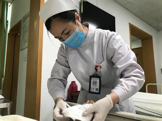 图为伤口专科护?#31354;?#38634;莹在为患者护理伤口