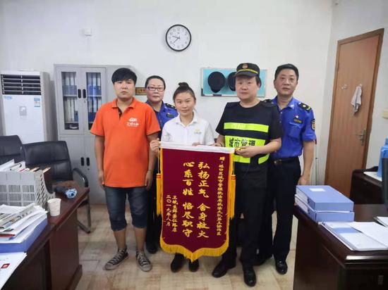 超市店長給硚口城管執(zhí)法大隊(duì)第三協(xié)作區(qū)贈送錦旗，右二為楊忠權(quán)
