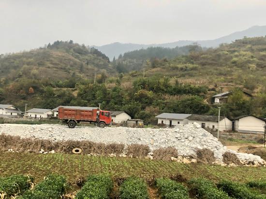 部分矿渣露天堆放在农田旁