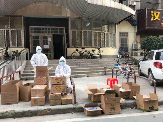 邢燕(左)和邢飞(右)在等候居民前来领取物资