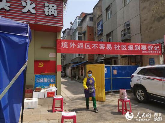 武汉市东西湖区一社区门口坚持防疫不松懈(周雯 摄)
