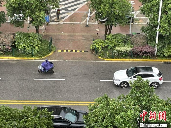 17日中午，武汉市民冒雨出行　马芙蓉　摄