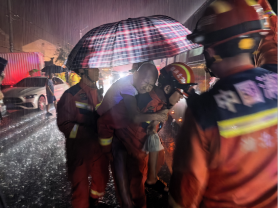 黄石市消防救援人员在雨中将行动困难老人转移至安全地带。 刘归华摄