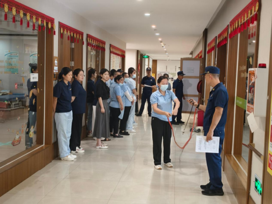 武汉市消防救援局消防员向养老服务机构医护、护理及消防控制室值班人员和后勤工作人员，实地讲解消防器材操作使用方法。&nbsp;&nbsp;&nbsp;李斌/摄