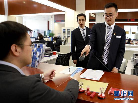 这是工作人员为天津花生好车汽贸有限公司董事长陈鹏云(左一)扫码登记。新华社发
