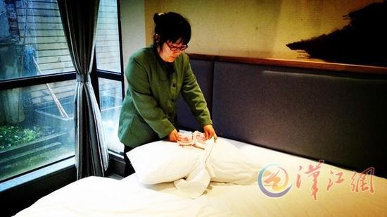 把錢塞進(jìn)枕頭套子里枕著睡覺，看似安全，然而一些客人睡醒后就忘了這事。圖為情景再現(xiàn)溫慶華在檢查枕套時發(fā)現(xiàn)客人遺留的現(xiàn)金