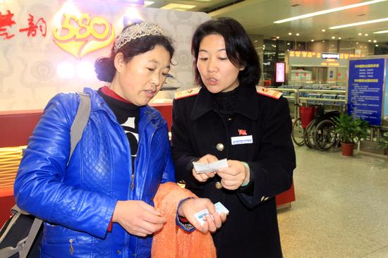 1－图一：除夕夜，武汉铁路局武昌车站值班站长罗明燕正在引导旅客乘车。今年是她在岗们上连续度过的第5个除夕之夜。（刘卫兵 摄）