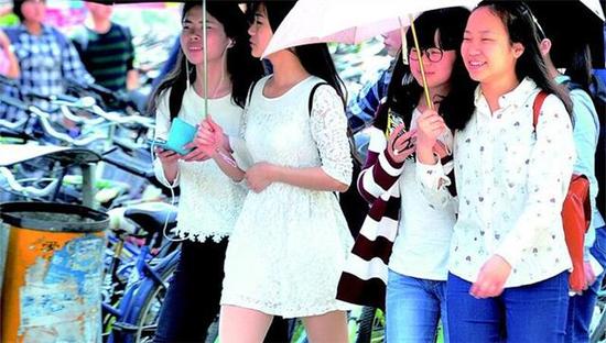 图为：昨日，江城阳光有点强，许多女孩打伞遮阳