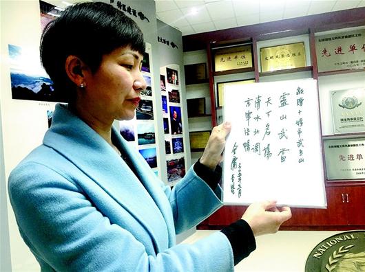 武當(dāng)山特區(qū)檔案局負責(zé)人展示金庸先生的題詞。