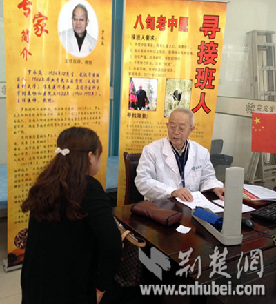 罗教授在医院的诊室内竖起两块寻找接班人
